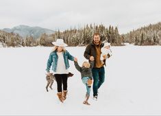 a family walking through the snow holding hands