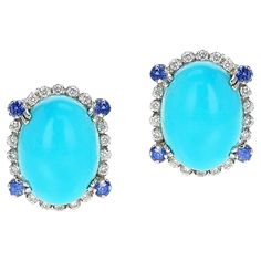 A Turquoise Oval Cabochon Earrings with Diamonds and Sapphire, 18k. The total weight of the diamonds is 0.80 carats and the sapphires weigh 0.40 carats. The earrings weigh 11.88 grams and the size is 0.75" x 0.60". The turquoise is 10 x 12 MM. Turquoise Oval Cabochon Wedding Jewelry, Turquoise Oval Fine Jewelry Earrings, Fine Jewelry Turquoise Oval Cabochon, Luxury Turquoise Oval Cabochon Jewelry, Blue Multi-stone Jewelry With Oval Cabochon, Cabochon Earrings, Sapphire Earrings, Oval Cabochon, Diamond Earrings