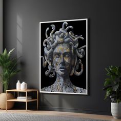 an art work is displayed on the wall next to a potted plant in a living room