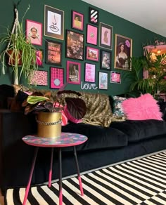 a living room filled with lots of furniture and pictures on the wall above it's black couch