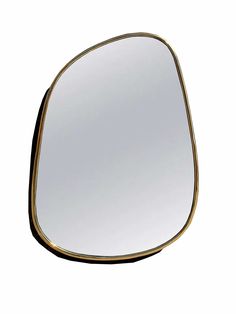 a mirror that is sitting on top of a white surface and has gold trim around the edges