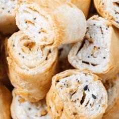 several rolls with black seeds on them stacked up in a pile and ready to be eaten