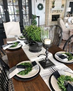 a dining room table set with plates and place settings