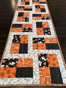 an orange and black quilted table runner