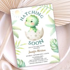 a card with a baby dinosaur in an egg shell on it's back and the words hatching soon