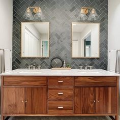 a bathroom with double sinks and two mirrors on the wall next to eachother