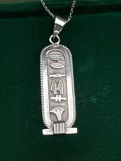 Vintage double sided Sterling Silver Egyptian Cartouche pendant;  necklace for women.Solid silver pendant.  Hieroglyphs silver necklace.  Circa 80s. Solid silver necklace. Silver pendant with chain. Egyptian necklace  Mark: Egyptian stamps.  Condition: pendant in perfect condition. Materials: 925 sterling silver chain. 800 Egyptian silver.  Measure: 1.6" x 0.5"/ 4.1 x 1.2 cm. Chain 16"/ 40 cm. Postage: Gift wrap available, please specify when ordering. Delivery: your order will be sent by Royal Mail with tracking information in 1-2 working days. Thanks for visiting. Egyptian Stamps, Egyptian Cartouche, Egyptian Necklace, Lucky Symbols, Egyptian Revival, 925 Sterling Silver Chain, Necklace For Women, Silver Pendant, Favorite Jewelry