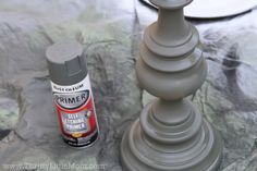 a close up of a spray paint next to a candle holder on a marble surface