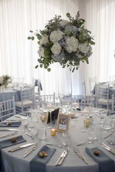 a table set with silverware and flowers in a vase on top of the table