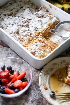 a close up of a plate of food with fruit on it and a pan of bread