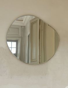 a round mirror hanging on the side of a wall