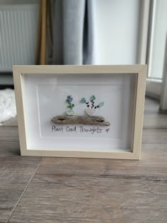 there are two small flowers in a white frame