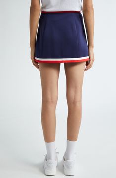 Sporty stripes highlight the waist of this preppy skirt boasting logo branding and comfortable stretch. Pull-on style 95% polyester, 5% spandex Dry clean or machine wash, line dry Imported Asian & Pacific Islander Owned/Founded Navy Fitted Sporty Skort, Sporty Fitted Navy Skort, Sporty Short Pleated Skirt, Sporty Mini Length Lined Tennis Skirt, Sporty Mini Length Tennis Skirt With Lining, Sporty Mini Length Skort With Lined Skirt, Sporty Elastane Mini Tennis Skirt, Sporty Mini Tennis Skirt In Elastane, Sporty Mini Skort With Lined Skirt