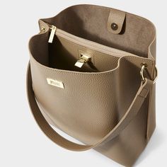 Our top-rated Reese Shoulder Bag in taupe is always a hit with your customers. The mixture of vegan leather design, gold-tone hardware, chic buckle fastening and sturdy shoulder strap secures this style as the ultimate everyday bag. Vegan Leather Height: 11" Depth: 5 15/16" Length: 11 7/16" Color: Taupe, Off White, Black Packaged and Shipped from Indianapolis, IN Copper And Grey, Taupe Colour, Everyday Bag, Leather Design, Phone Numbers, Vegan Leather, Leather Bag, Pu Leather, Product Launch