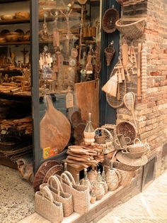 baskets and other items are on display in front of a store window with brick walls