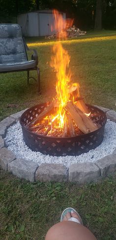 someone is sitting in front of a fire pit