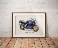 a framed photograph of a blue motorcycle on a wooden floor