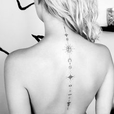 the back of a woman's neck with stars and moon tattoos on her lower back