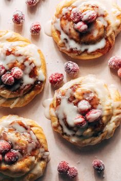 several pastries covered in icing and cranberries