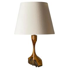 a wooden table lamp with a white shade