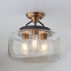 three light semi flush ceiling fixture with clear glass and bronze finish, on white background