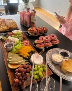 a woman sitting at a table full of food looking at her cell phone