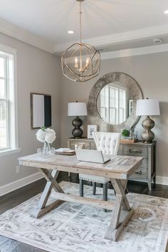 a dining room table with a laptop on top of it in front of a mirror