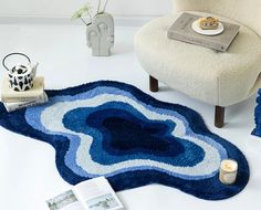 a living room with a blue rug on the floor next to a chair and coffee table