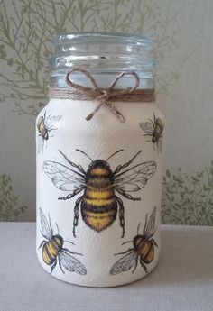 a mason jar with bees painted on it