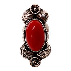 This is part of Chairish’s Costume Jewelry assortment.  A fine vintage silver Native American ring featuring a large deep colored red bezel set cabochon coral. Each side is decorated with an engraved flower and leaves. There is a rope twist border around the coral's beze. There are no marks and it tests silver. Condition is excellent.  Dimensions:  Size 6 3/4, Top length: 1 3/4", Largest width: 7/8", Weight: 14.1 grams Bezel Set Cabochon, Flower And Leaves, Green Cocktail, Engraved Flower, Native American Rings, Rope Twist, Gold Cocktail Ring, Gold Cocktail, Deep Colors