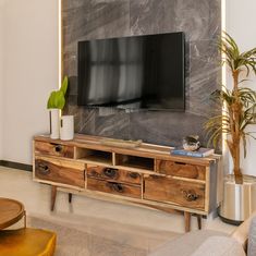 a living room with a large television mounted on the wall next to a wooden table