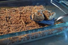 a glass casserole dish filled with brownies and crumbs