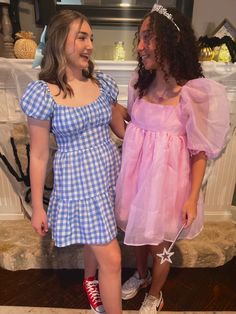 two girls dressed in costumes standing next to each other