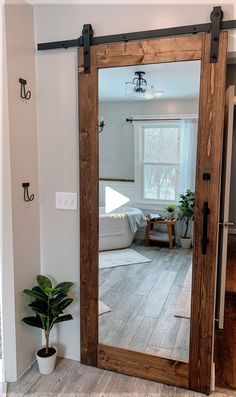 a large mirror in the middle of a room with a potted plant on the floor