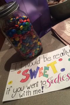 a jar full of candy next to a sign that says it would be really sweet if you went to the studio with me