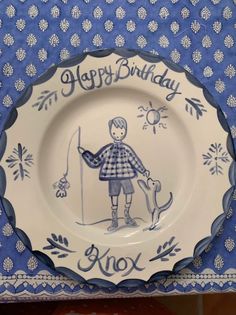 a blue and white plate with an image of a boy holding a dog on it