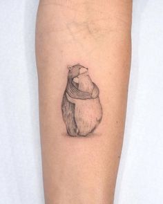 a small bear tattoo on the arm