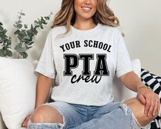 a woman sitting on a couch wearing a t - shirt that says your school pta crew