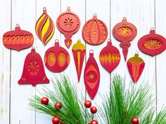 a bunch of ornaments hanging from the side of a wooden wall next to a pine tree