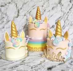 three unicorn themed cakes sitting on top of a marble counter