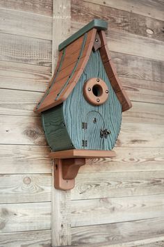 a wooden birdhouse mounted to the side of a wall