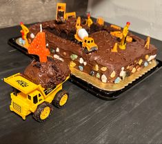 a birthday cake with construction themed decorations on it and a dump truck next to it