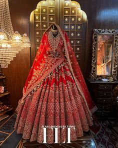 a red bridal gown on display in front of a mirror