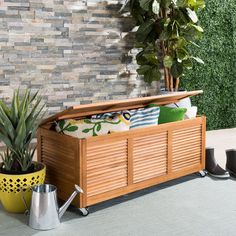 a wooden bench sitting next to a potted plant