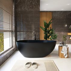 a large black bath tub sitting next to a window