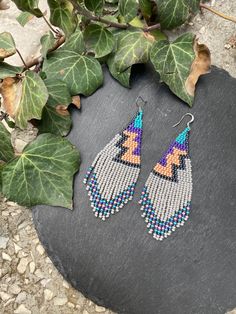 Gray zigzag bead earrings, Purple geometric beaded fringe earrings, Abstract contemporary earrings, Wearable art ,Beige gray earrings ♥𝑇ℎ𝑒 𝑝𝑎𝑡𝑡𝑒𝑟𝑛 𝑜𝑓 𝑡ℎ𝑖𝑠 𝑒𝑎𝑟𝑟𝑖𝑛𝑔 𝑖𝑠 𝑐𝑟𝑒𝑎𝑡𝑒𝑑 𝑏𝑦 𝐾𝑎𝑍𝑒𝐵𝑒𝑎𝑑𝐽𝑒𝑤𝑒𝑙𝑟𝑦 ♥𝑀𝑎𝑑𝑒 𝑢𝑠𝑖𝑛𝑔 𝑓𝑟𝑒𝑒ℎ𝑎𝑛𝑑 𝑏𝑒𝑎𝑑𝑖𝑛𝑔 𝑤𝑜𝑣𝑒𝑛 𝑡𝑒𝑐ℎ𝑛𝑖𝑞𝑢𝑒𝑠 𝑤𝑖𝑡ℎ 𝑠𝑡𝑟𝑜𝑛𝑔 𝑠𝑦𝑛𝑡ℎ𝑒𝑡𝑖𝑐 𝑡ℎ𝑟𝑒𝑎𝑑. ♥𝑇ℎ𝑒 𝑠𝑖𝑧𝑒 𝑜𝑓 𝑡ℎ𝑒 𝑠𝑒𝑒𝑑 𝑏𝑒𝑎𝑑𝑠 𝑢𝑠𝑒𝑑 𝑖𝑠 2 𝑚𝑖𝑙𝑙𝑖𝑚𝑒𝑡𝑒𝑟𝑠 𝑎𝑛𝑑 𝑏𝑒𝑎𝑑𝑠 𝑎𝑟𝑒 ℎ𝑖𝑔ℎ 𝑞𝑢𝑎𝑙𝑖𝑓𝑖𝑒𝑑. ♥𝐴𝑙𝑙 𝑡ℎ𝑒 ℎ𝑜𝑜𝑘𝑠 𝑢𝑠𝑒𝑑 𝑖𝑛 𝑜𝑢𝑟 𝑗𝑒𝑤𝑒𝑙𝑟𝑦 𝑎𝑟𝑒 24 𝑘 𝑔𝑜𝑙𝑑 𝑝𝑙𝑎𝑡𝑒𝑑 𝑎𝑛𝑑 ℎ𝑦𝑝𝑜𝑎𝑙𝑙𝑒𝑟𝑔𝑒𝑛𝑖𝑐. ♥𝑇ℎ𝑒𝑠𝑒 𝑎𝑟𝑒 𝑣𝑒𝑟𝑦 𝑙𝑖𝑔ℎ𝑡 𝑒𝑎𝑟𝑟𝑖𝑛𝑔𝑠 𝑡ℎ𝑎𝑡 𝑦𝑜𝑢 𝑐𝑎𝑛 𝑤𝑒𝑎𝑟 𝑎𝑙𝑙 𝑑𝑎𝑦 𝑤𝑖𝑡ℎ𝑜𝑢𝑡 ℎ𝑢𝑟𝑡𝑖𝑛𝑔 𝑦𝑜𝑢𝑟 𝑒𝑎𝑟! The only acc Beaded Fringe Earrings, Beadwork Designs, Gray Earrings, Beaded Earring, Contemporary Earrings, Light Earrings, Earring Ideas, Earrings Purple, Beaded Fringe