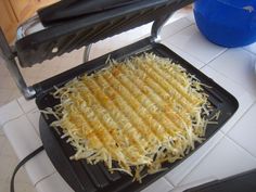 a griddle with cheese on it sitting on a counter