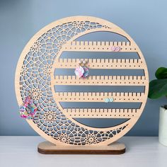 a clock made out of wooden pegs on top of a table next to a potted plant