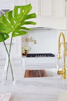 a kitchen with marble counter tops and gold faucet