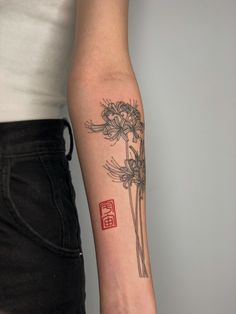 a woman's arm with a flower tattoo on the left side of her arm